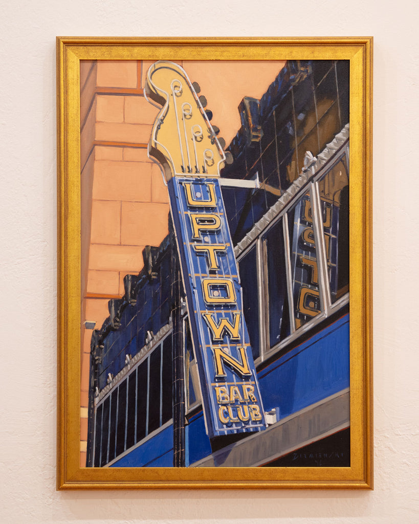 Framed artwork of a guitar with 'Uptown Bar Club' sign on a city street.